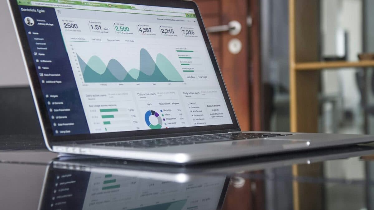 Portatile argentato su una scrivania scura, con una dashboard di statistiche nel browser.